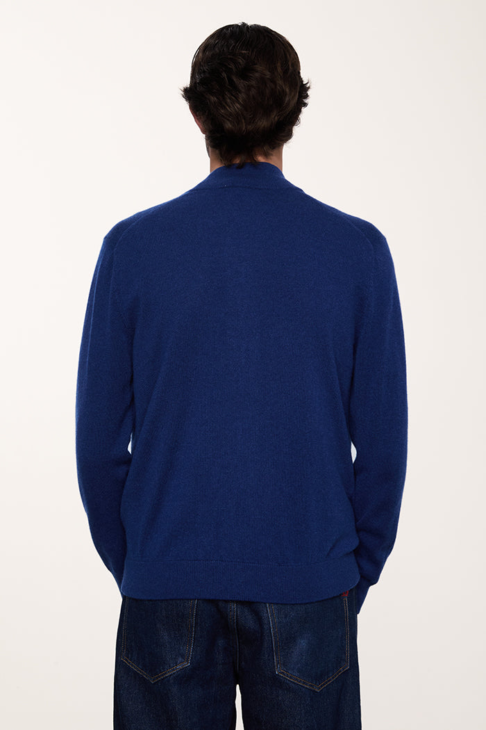 Foto dettaglio retro del cardigan con tasche laterali in puro cashmere da uomo colore blu chiaro. Maglieria made in Italy.